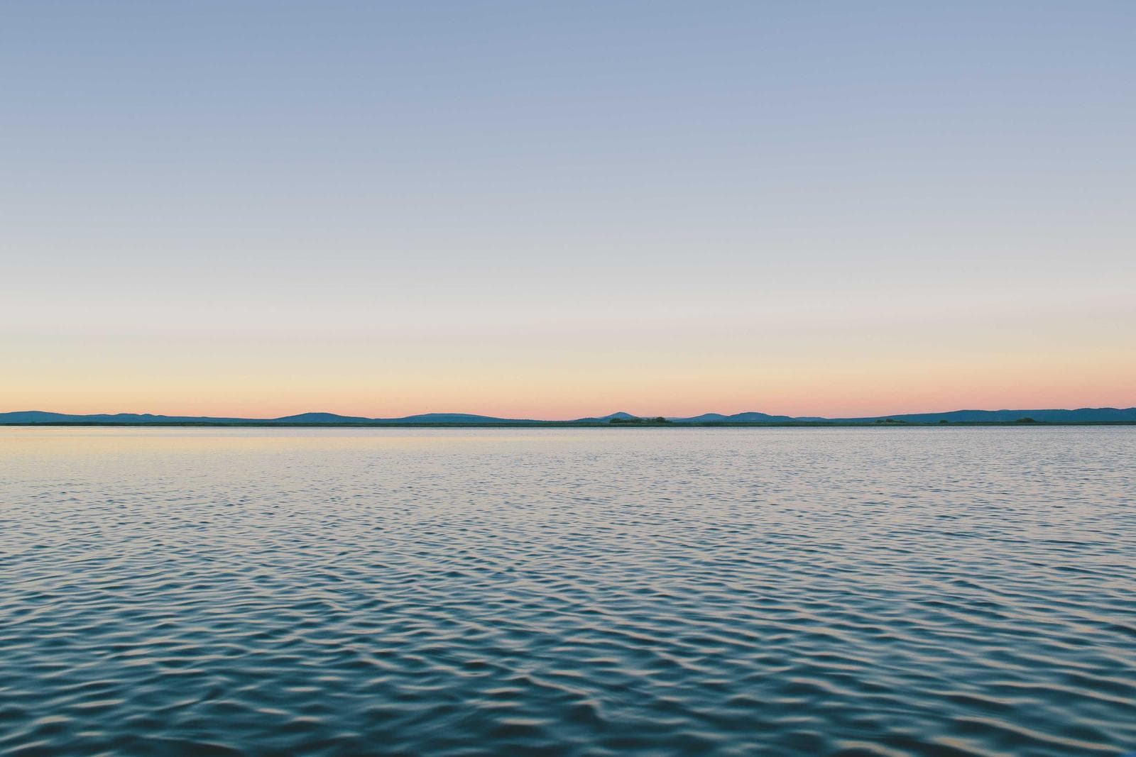Flat water meeting an empty sky