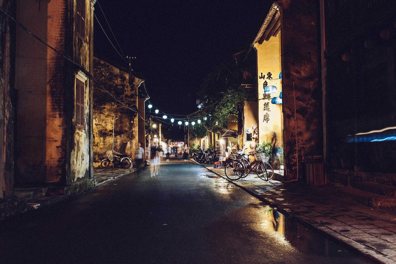 Shopfront light on a wet street at night